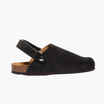 Black suede clog with cork sole and adjustable back velcro strap, displayed on a white background.